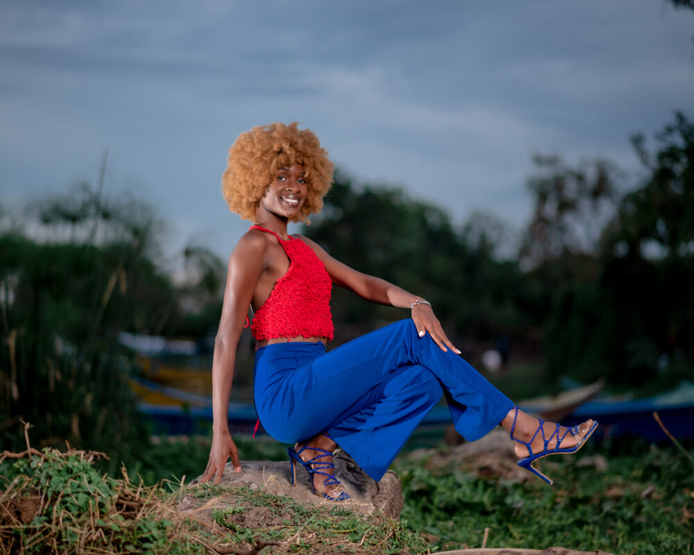 Quiller in a loop stitch bralette, named Parrot Chatty Bralette, made from organic cotton in red in front of Lake Victoria's shore.